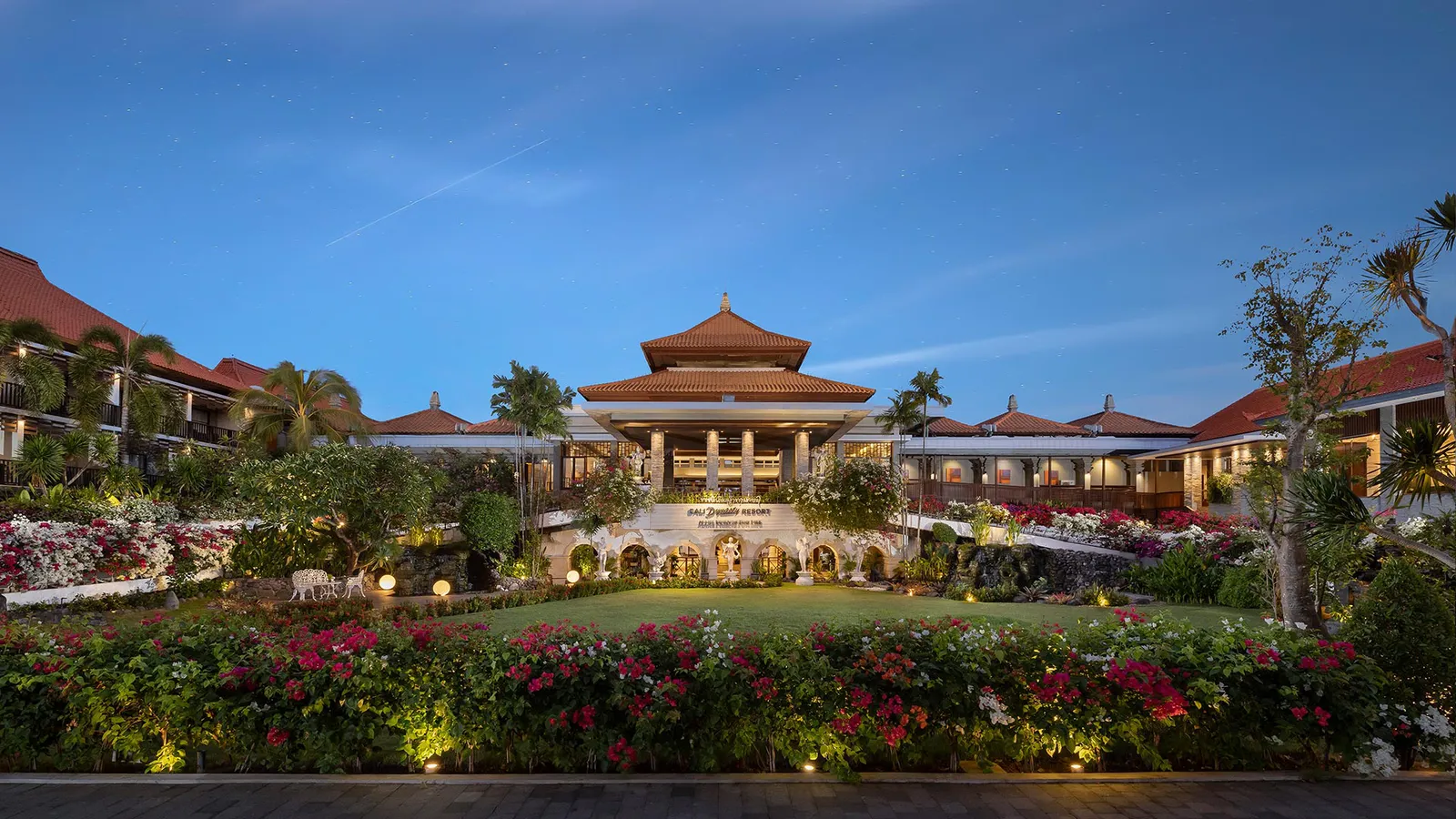 The tropical front gardens and lawns of Bali Dynasty Resort
