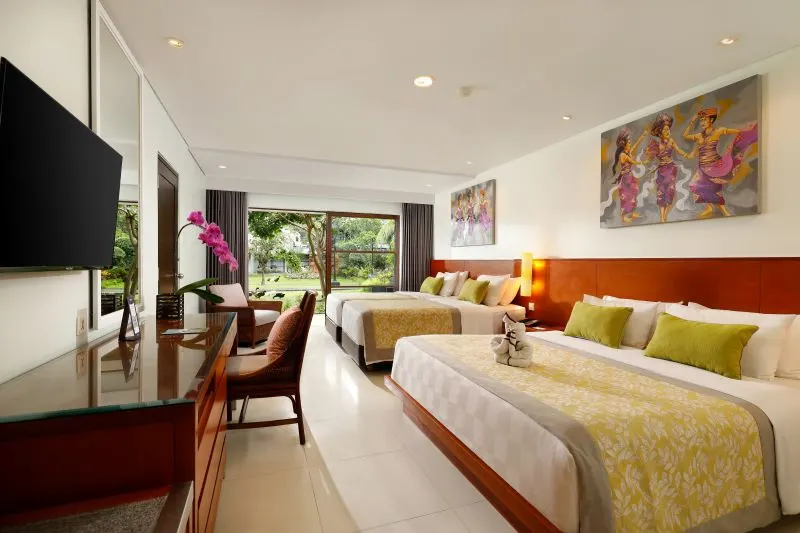 A Family Lagoon Pool Access room at Bali Dynasty Resort, showing the king bed, bright interiors, and terrace doors