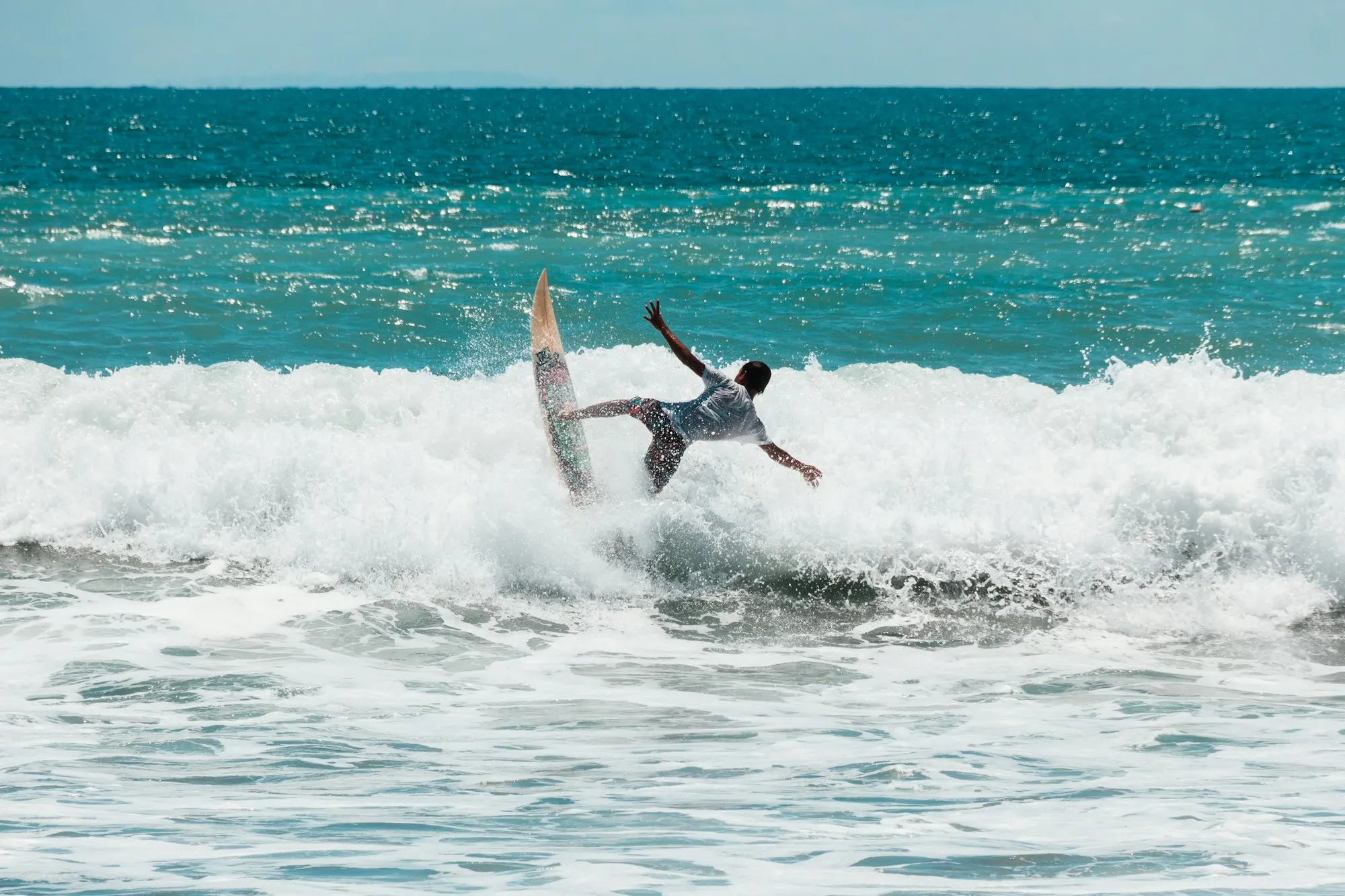 Surfers on the long golden sweep of Kuta Beach